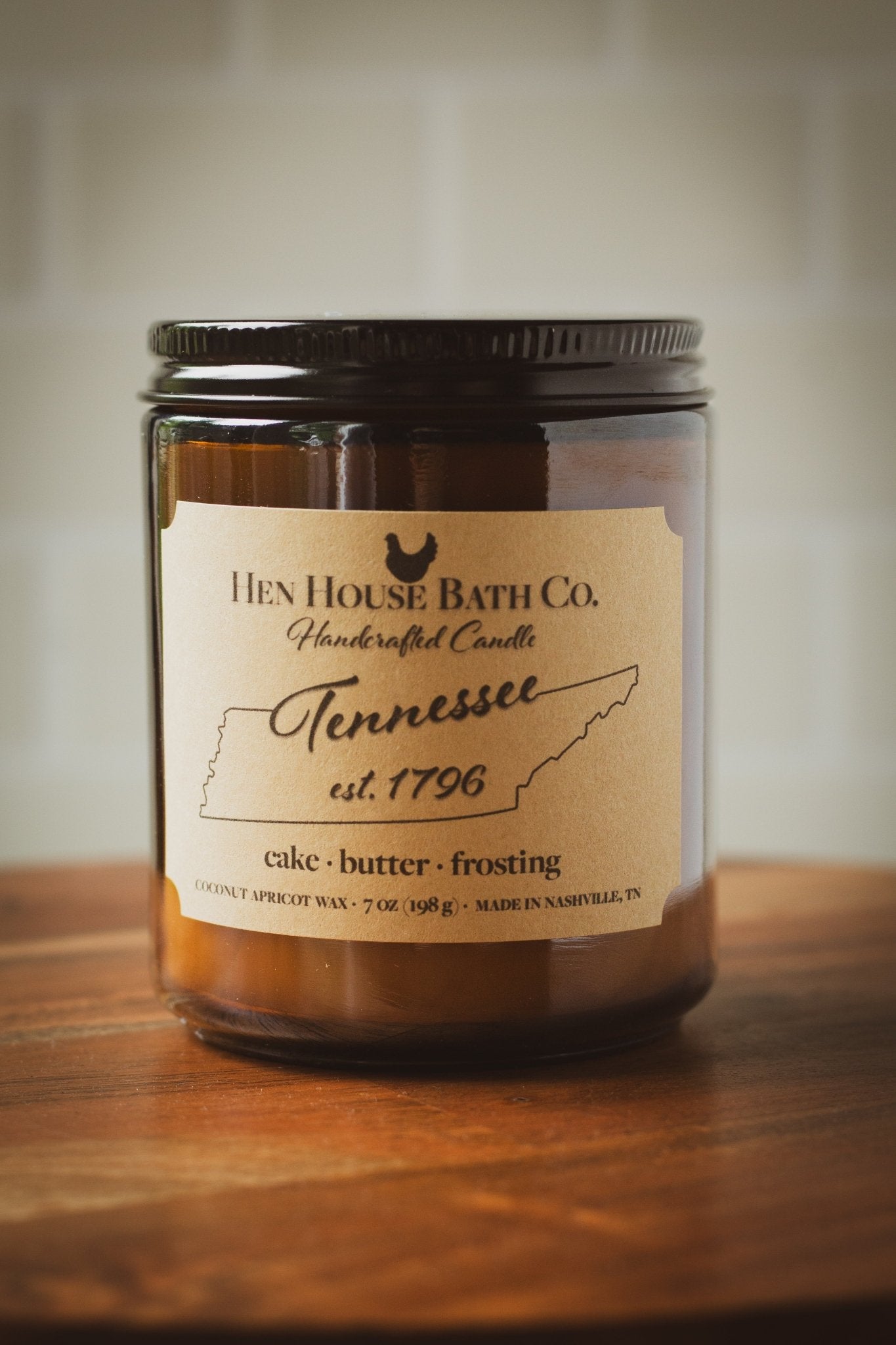 Est. 1796 wooden wick candle - birthday cake, vanilla, & almond scent. In an amber jar by Hen House Bath Co.